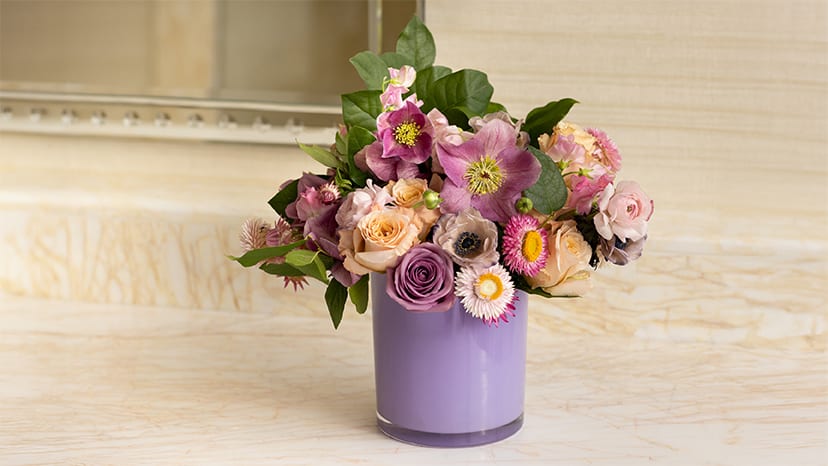 A bouquet of various flowers in a purple vase