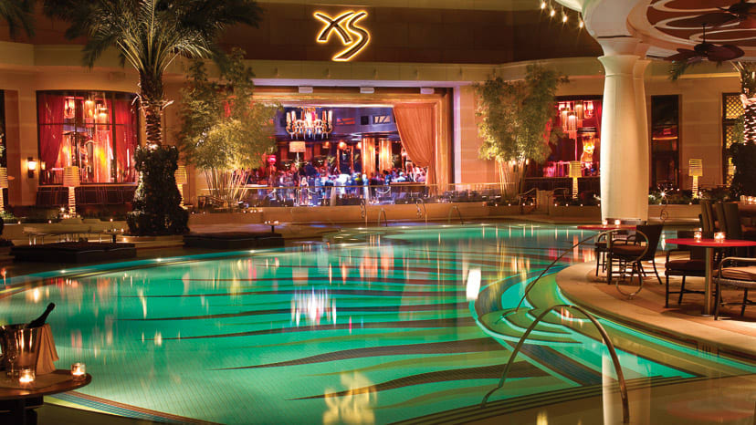 XS Nightclub Las Vegas interior lounge and pool area with gold-accented seating and central pavilion