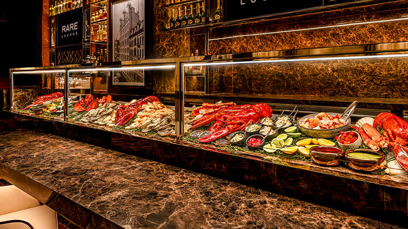 A selection of seafood on ice under a glass case