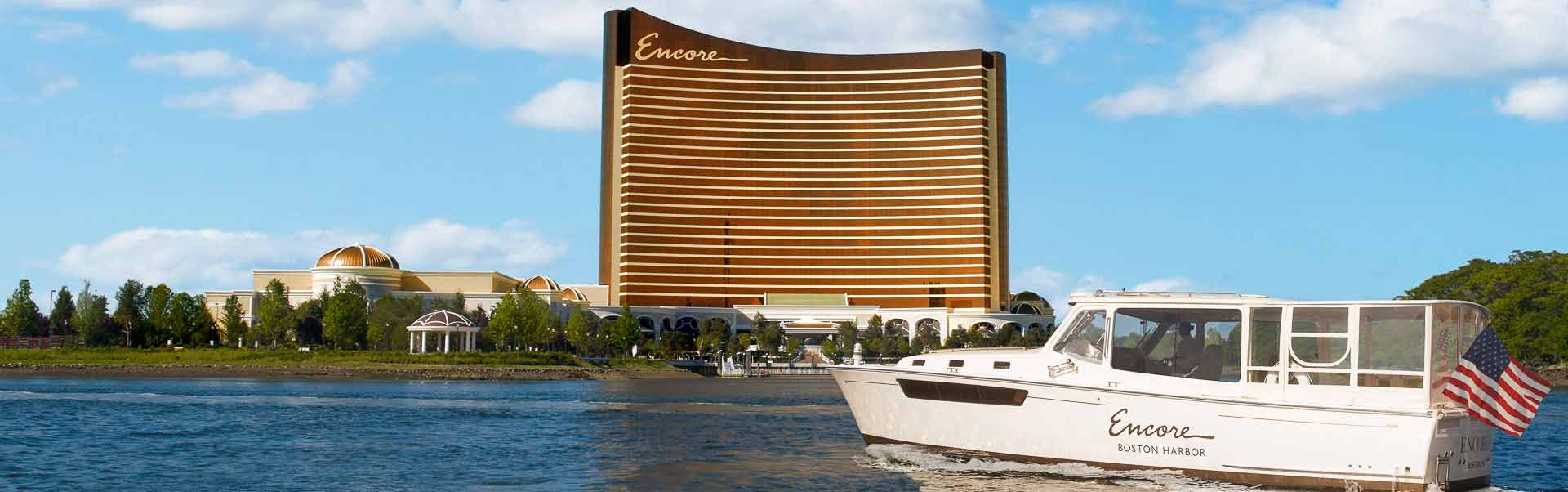 The harbor shuttle drives in front of the exterior of the resort tower at Encore Boston Harbor