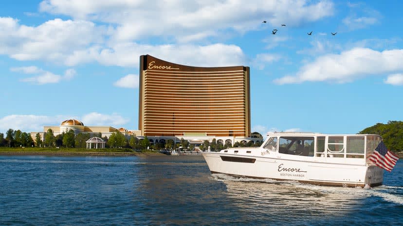 The Encore Harbor Shuttle drives in front of the exterior of Encore Boston Harbor