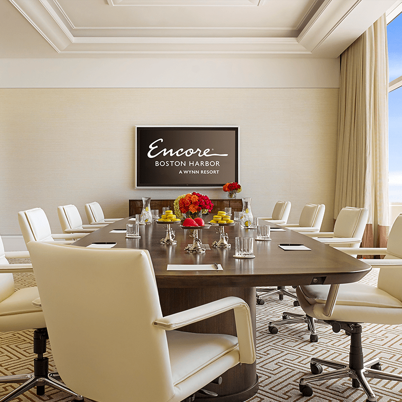 The interior of a meeting room at Encore Boston Harbor with a desk and several swivel chairs