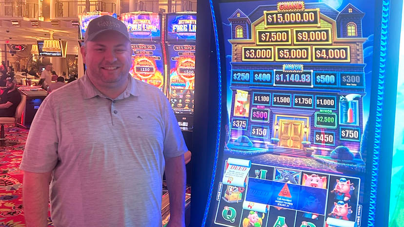 A guest stands next to a slot machine