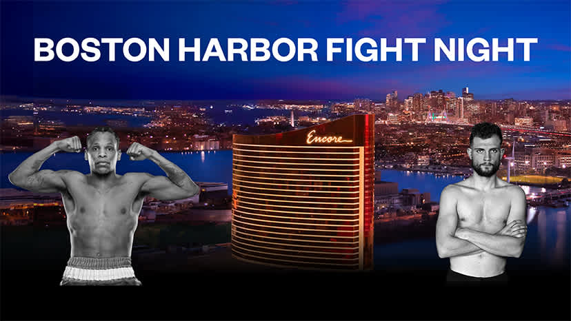 The exterior of Encore Boston Harbor with the Boston skyline behind it during a sunset