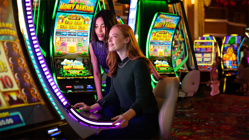 A woman sits and plays a slot machine